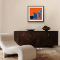 Vivid Echoes giclée print by Louise Turnbull displayed with a white mount and wooden frame above a dark wood sideboard in a contemporary neutral living room.