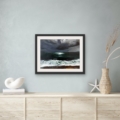 Yearning For seascape giclée print by Louise Turnbull displayed in a black frame with white mount above a pale wood sideboard in a coastal-inspired interior.